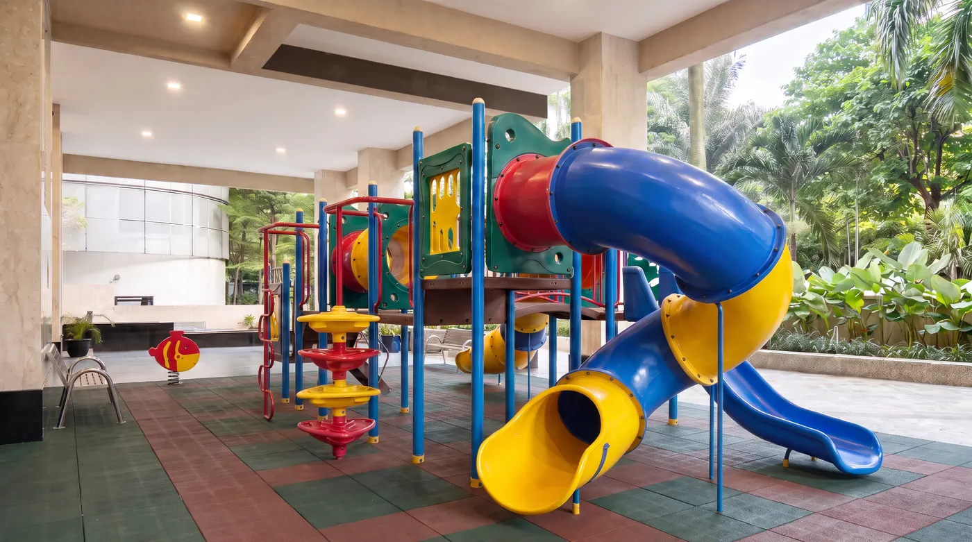 Covered outdoor playground with slides beside the garden